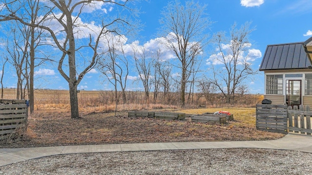 view of yard featuring a rural view and a vegetable garden