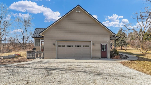 view of property exterior with driveway and metal roof