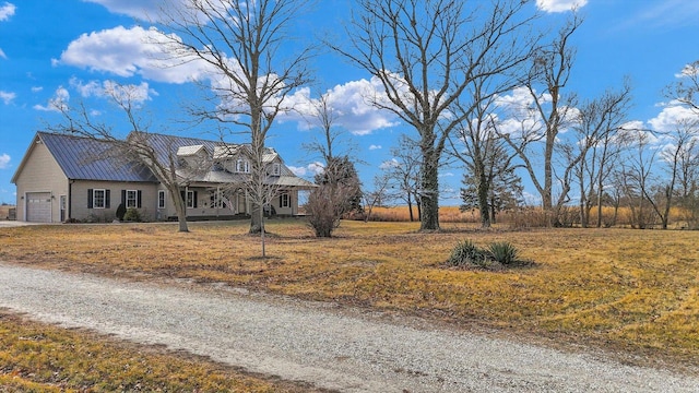 exterior space with a front lawn, metal roof, driveway, and an attached garage