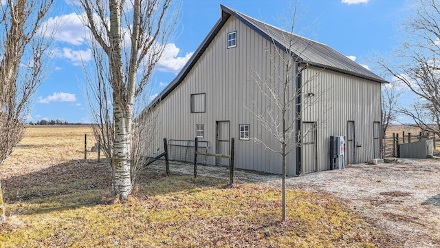 view of side of home with fence and an outbuilding