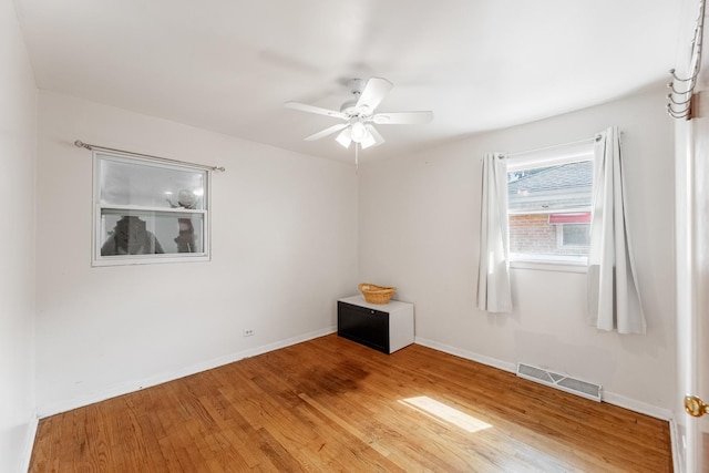 empty room with hardwood / wood-style flooring and ceiling fan