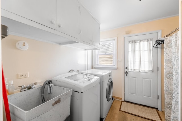 laundry area featuring sink, crown molding, cabinets, light hardwood / wood-style floors, and separate washer and dryer