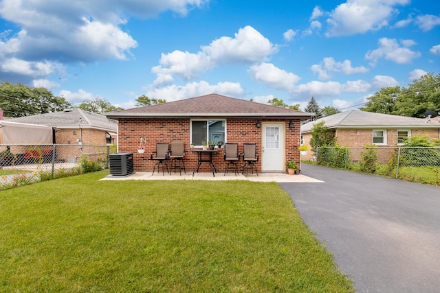 rear view of house featuring central AC, a yard, and a patio area