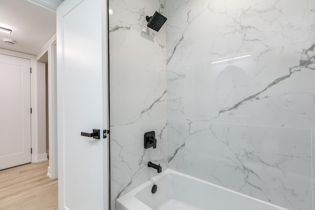 bathroom with hardwood / wood-style floors and tiled shower / bath combo