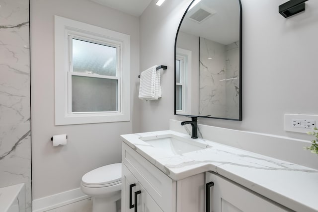 bathroom featuring vanity, a shower, and toilet