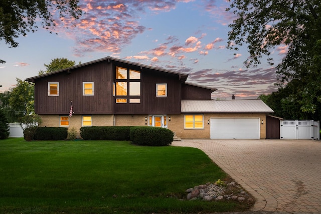 view of front facade with a garage and a lawn