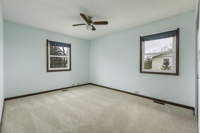 spare room with ceiling fan and light colored carpet