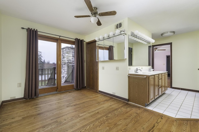 kitchen with ceiling fan, sink, and light wood-type flooring