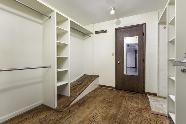 walk in closet with dark hardwood / wood-style floors