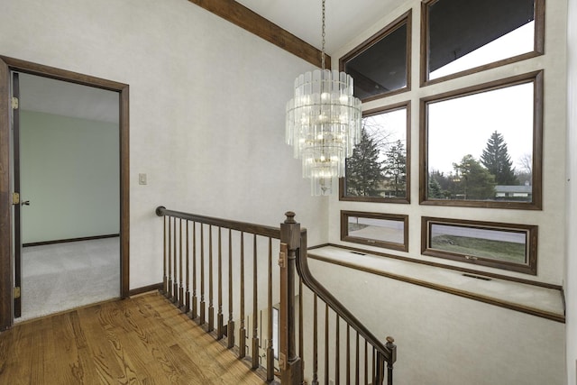 staircase with an inviting chandelier and hardwood / wood-style flooring