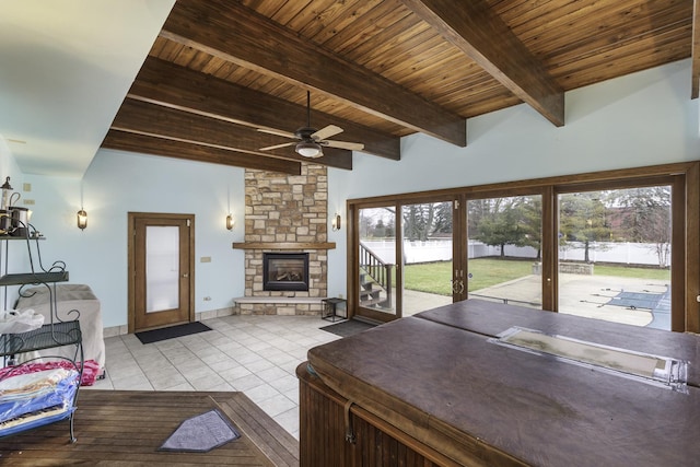 living room featuring wooden ceiling, light tile patterned floors, beamed ceiling, ceiling fan, and a fireplace