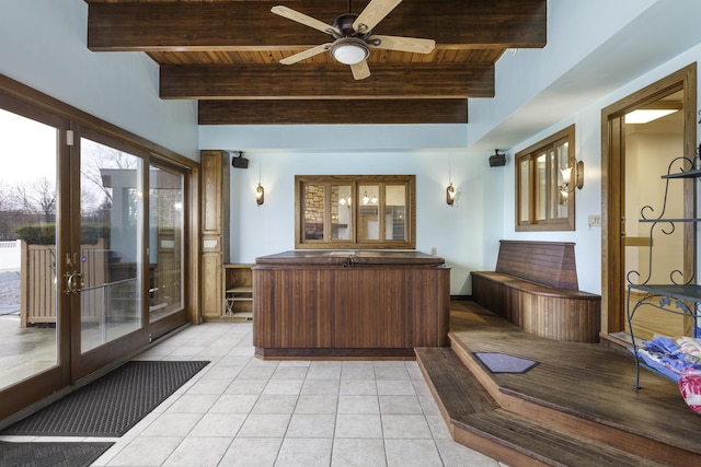 interior space with wood ceiling, ceiling fan, light tile patterned floors, and beamed ceiling