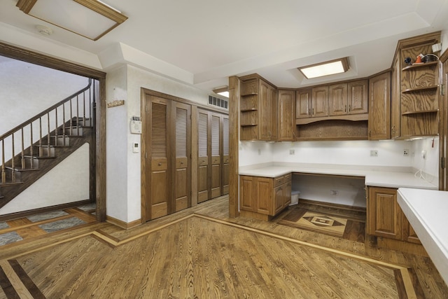 unfurnished office featuring built in desk and dark hardwood / wood-style flooring