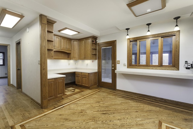 kitchen with pendant lighting, built in desk, and dark hardwood / wood-style flooring