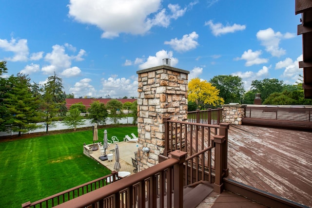 deck featuring a water view and a lawn