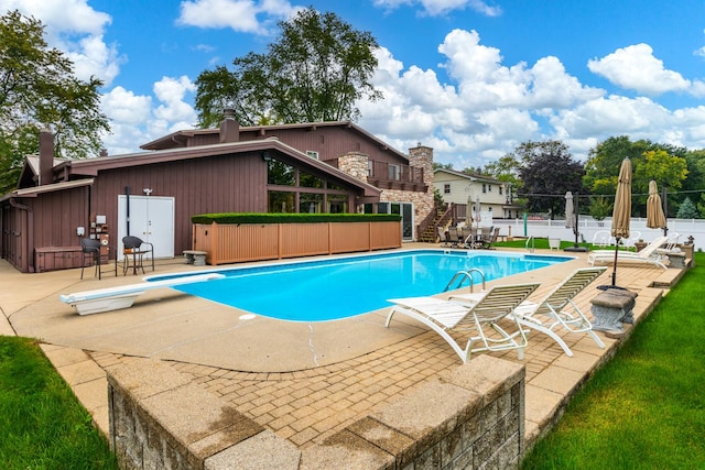 view of swimming pool with a patio, a jacuzzi, and a diving board