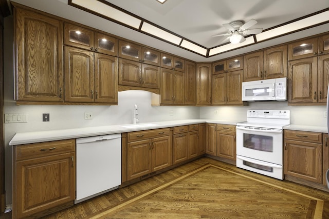 kitchen with sink, white appliances, ceiling fan, dark hardwood / wood-style floors, and a raised ceiling