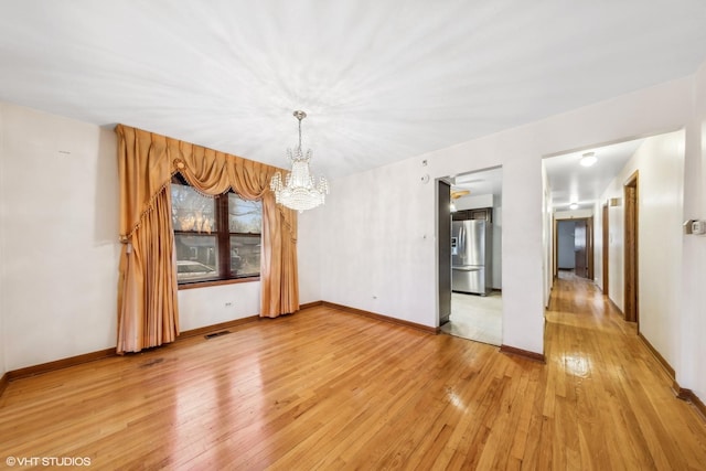 unfurnished dining area with hardwood / wood-style flooring and an inviting chandelier