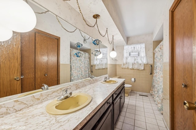 bathroom with tile patterned floors, toilet, a shower with curtain, tile walls, and vanity