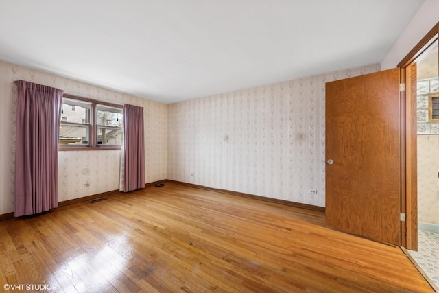 unfurnished room with light wood-type flooring