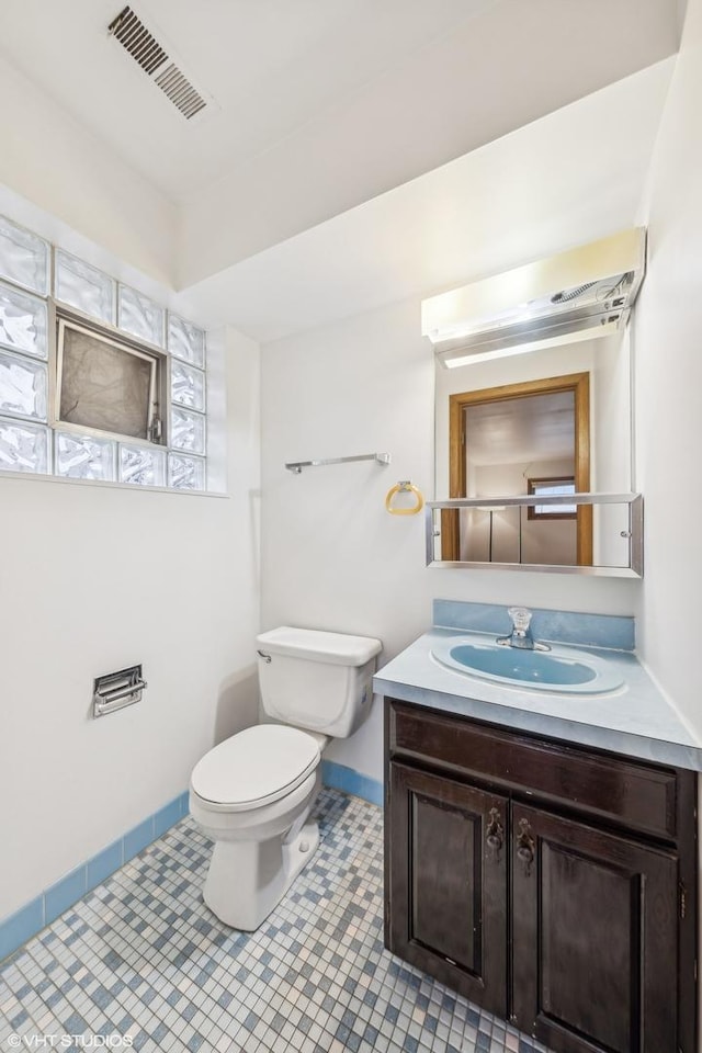 bathroom with vanity, toilet, and tile patterned flooring