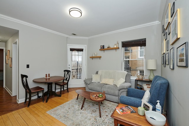 living room with hardwood / wood-style floors, crown molding, and plenty of natural light