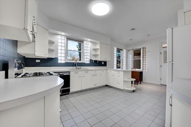 kitchen with backsplash, dishwasher, sink, and white cabinets