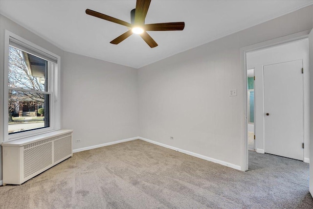 carpeted spare room with radiator heating unit and ceiling fan