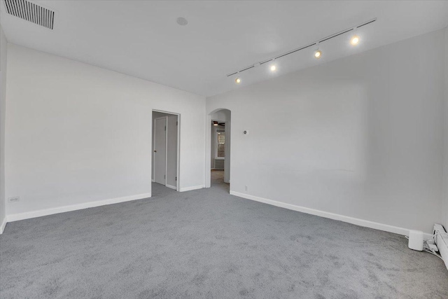 unfurnished room with rail lighting and carpet flooring