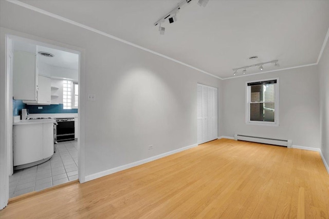 unfurnished room with crown molding, light wood-type flooring, and baseboard heating