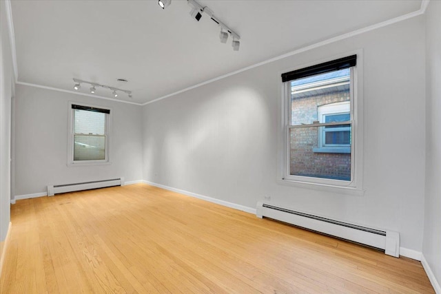 spare room with light hardwood / wood-style flooring, crown molding, and a baseboard radiator