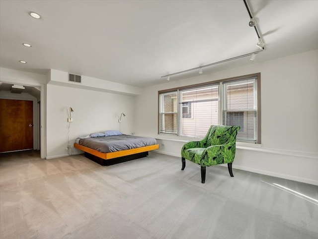 bedroom featuring light carpet and track lighting