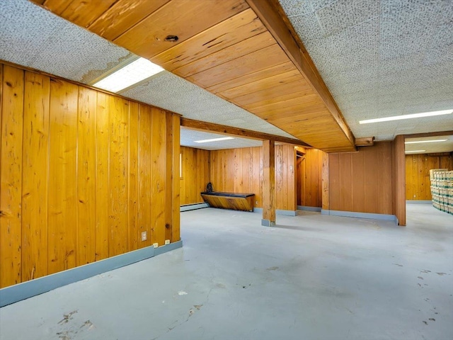 basement featuring a baseboard radiator and wooden walls