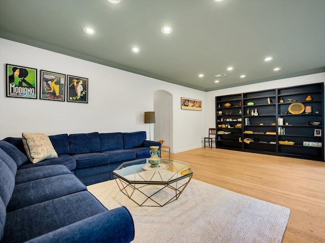 living room with built in features and light wood-type flooring