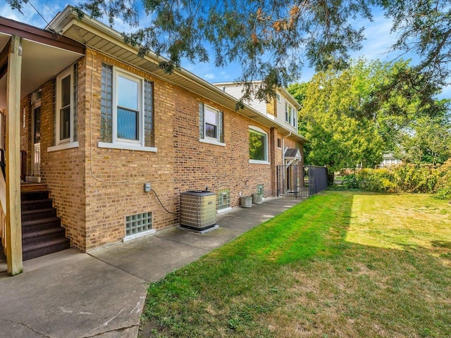 view of property exterior with central AC and a lawn