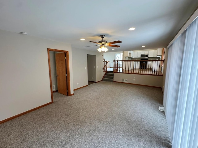 spare room featuring ceiling fan and light carpet