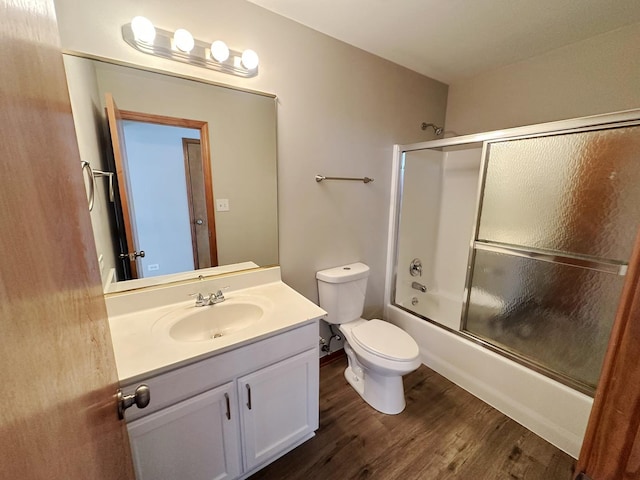 full bathroom with enclosed tub / shower combo, wood-type flooring, toilet, and vanity