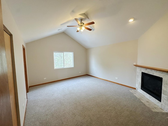 unfurnished living room featuring a tile fireplace, lofted ceiling, light carpet, and ceiling fan