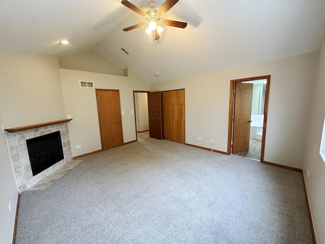 unfurnished living room with ceiling fan, lofted ceiling, light colored carpet, and a fireplace