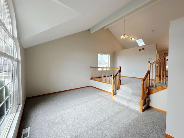 empty room featuring carpet flooring, beam ceiling, a chandelier, and high vaulted ceiling