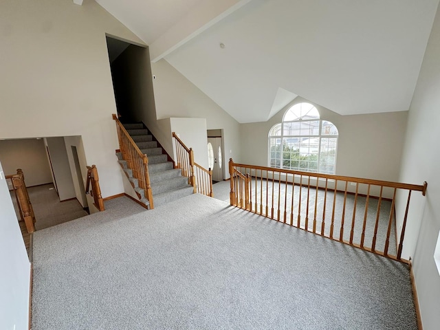 interior space with high vaulted ceiling, beamed ceiling, and carpet