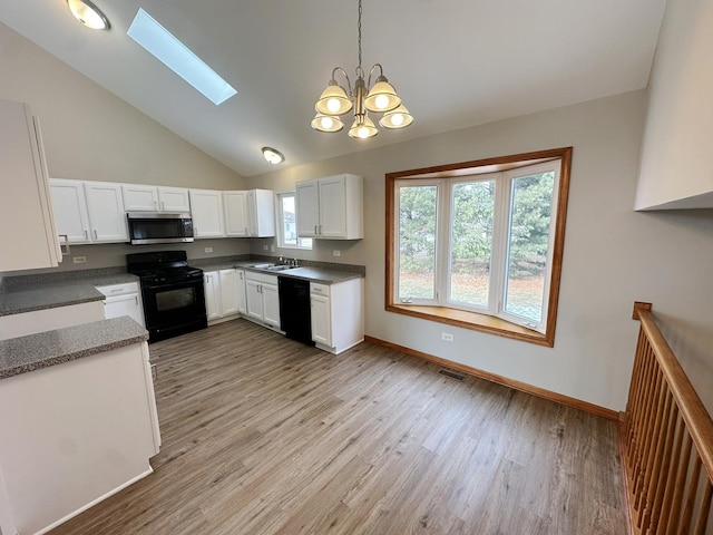 kitchen with a skylight, sink, white cabinets, hanging light fixtures, and black appliances