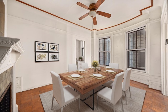 dining space featuring ceiling fan and dark parquet flooring