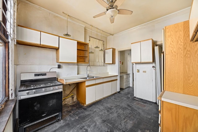 kitchen with stainless steel gas stove, sink, white cabinetry, and ceiling fan