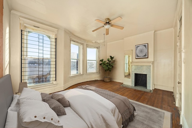 bedroom with crown molding, ceiling fan, and dark hardwood / wood-style flooring