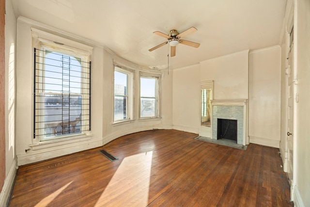 unfurnished living room featuring dark wood-type flooring, ceiling fan, and ornamental molding