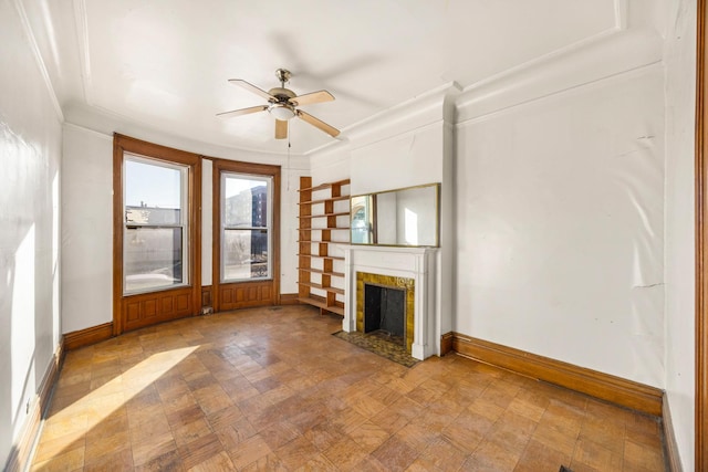 unfurnished living room featuring crown molding and ceiling fan