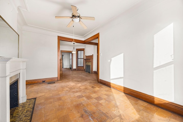 unfurnished living room featuring ceiling fan and ornamental molding