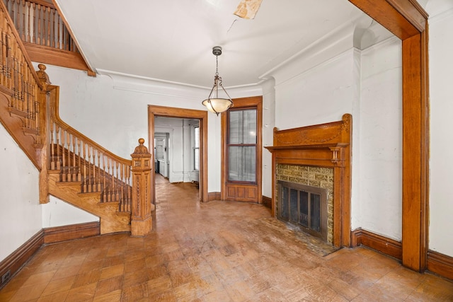 unfurnished living room with crown molding and a stone fireplace