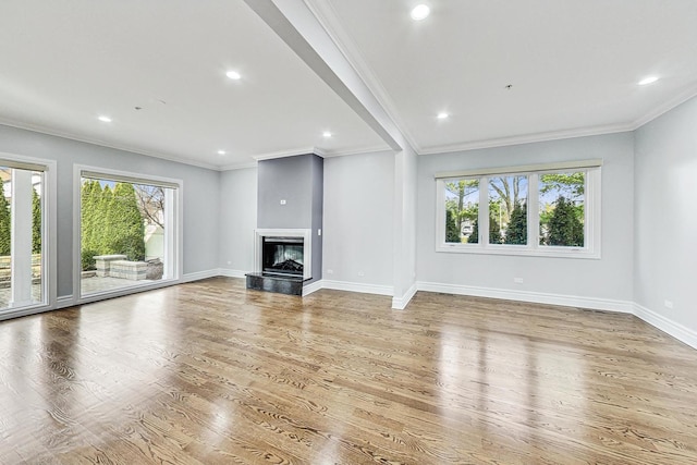 unfurnished living room with ornamental molding and light hardwood / wood-style floors